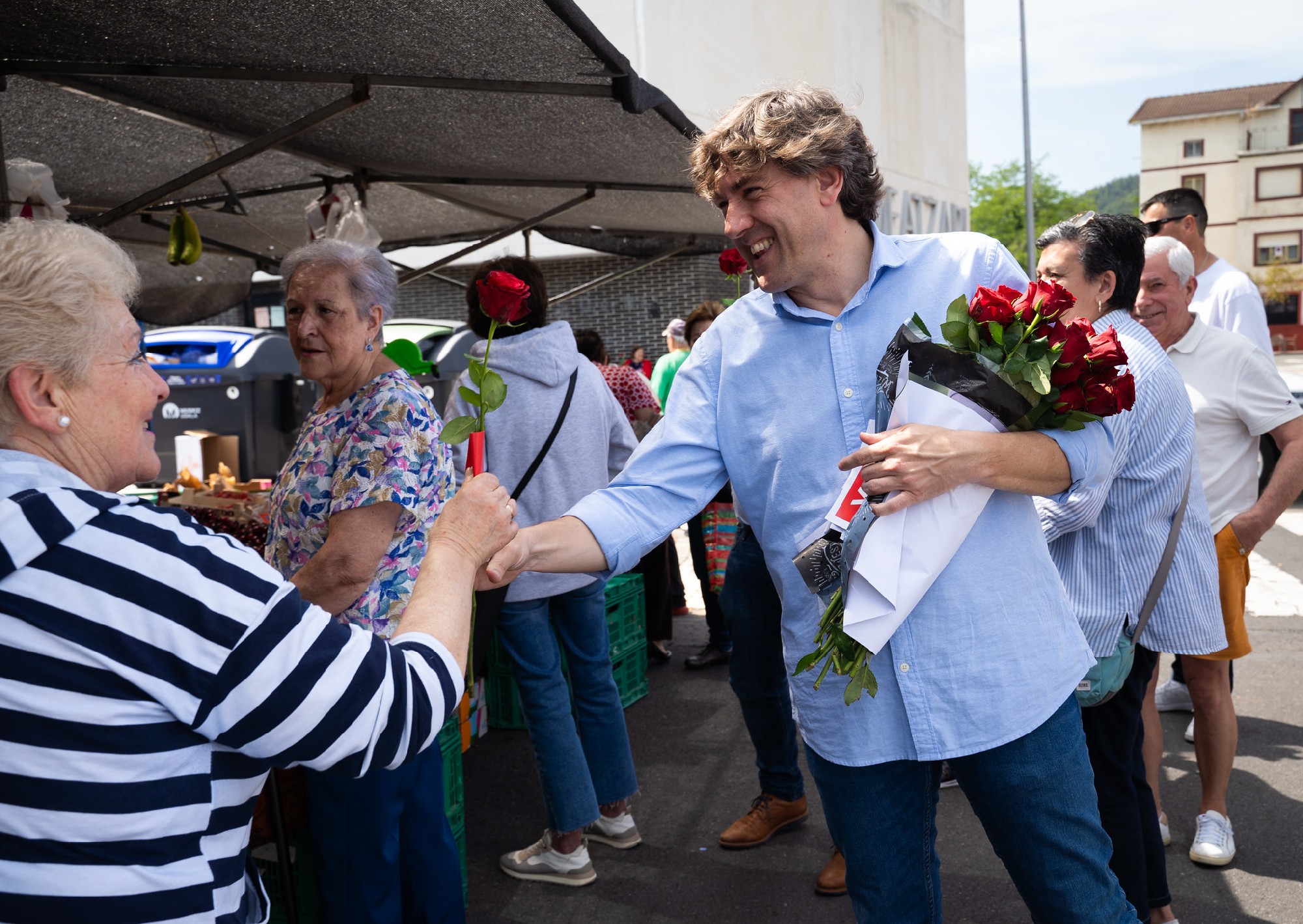 El Secretario General del PSE-EE, Eneko Andueza, durante el reparto de rosas en el mercadillo de Muskiz | Foto: Socialistas Vascos